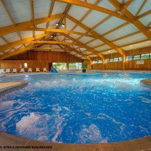 Piscine couverte chauffée avec bains à remous Camping Beauregard **** SItes & Paysages à Mesnois, au coeur de la région des lacs - Jura